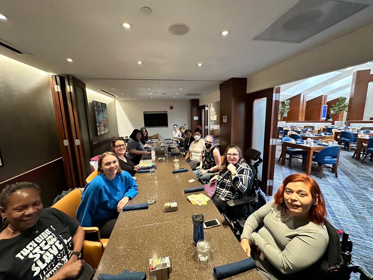 US Alliance members sit together around a long dining table during the in-person convening in Washington, DC, sharing conversation and connection.