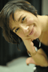 Photo of Nicole (she/her) She has short dark hair that sits right at her ears. Nicole is a 41yr old Latina/Hispanic female.  In the photo she has a big smile spread across her face & is wearing a black dance leotard. 